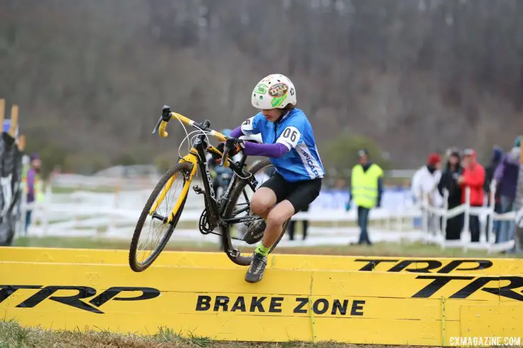 Kids are often well-served to step on the barriers, rather than trying to step over them. Seamus Quigley shows how to do it. Junior Men 11-12, 2016 Cyclocross National Championships. © Cyclocross Magazine