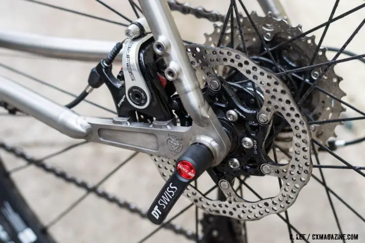 The Sage Cycles logo is engraved on the thru axle 'dropout' with flat mount disc brake mounts and threaded mounts for rack and fender. ©️ Clifford Lee / Cyclocross Magazine
