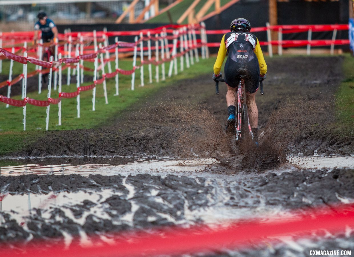 Sammi Runnels muddies up her Squid in a puddle left by the week of rain. Collegiate Varsity Women. 2019 Cyclocross National Championships, Lakewood, WA. © A. Yee / Cyclocross Magazine